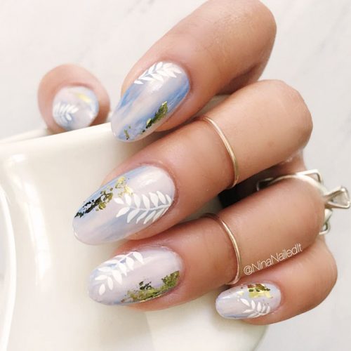 Shellac Nails With Gold Foil Design And Delicate Tropical Leaves #pastelnails #ovalnails #foilnails #tropicalnails