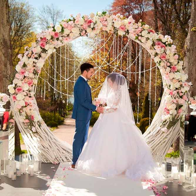 A Romantic Wedding Arch With Flowers And Beads #outdoorweddingarchway #flowersweddingarch