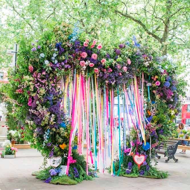 A Bright Colorful Ribbon And Flowers Arch #heartshapedweddingarch #ribbonweddingarch #modernweddingarch