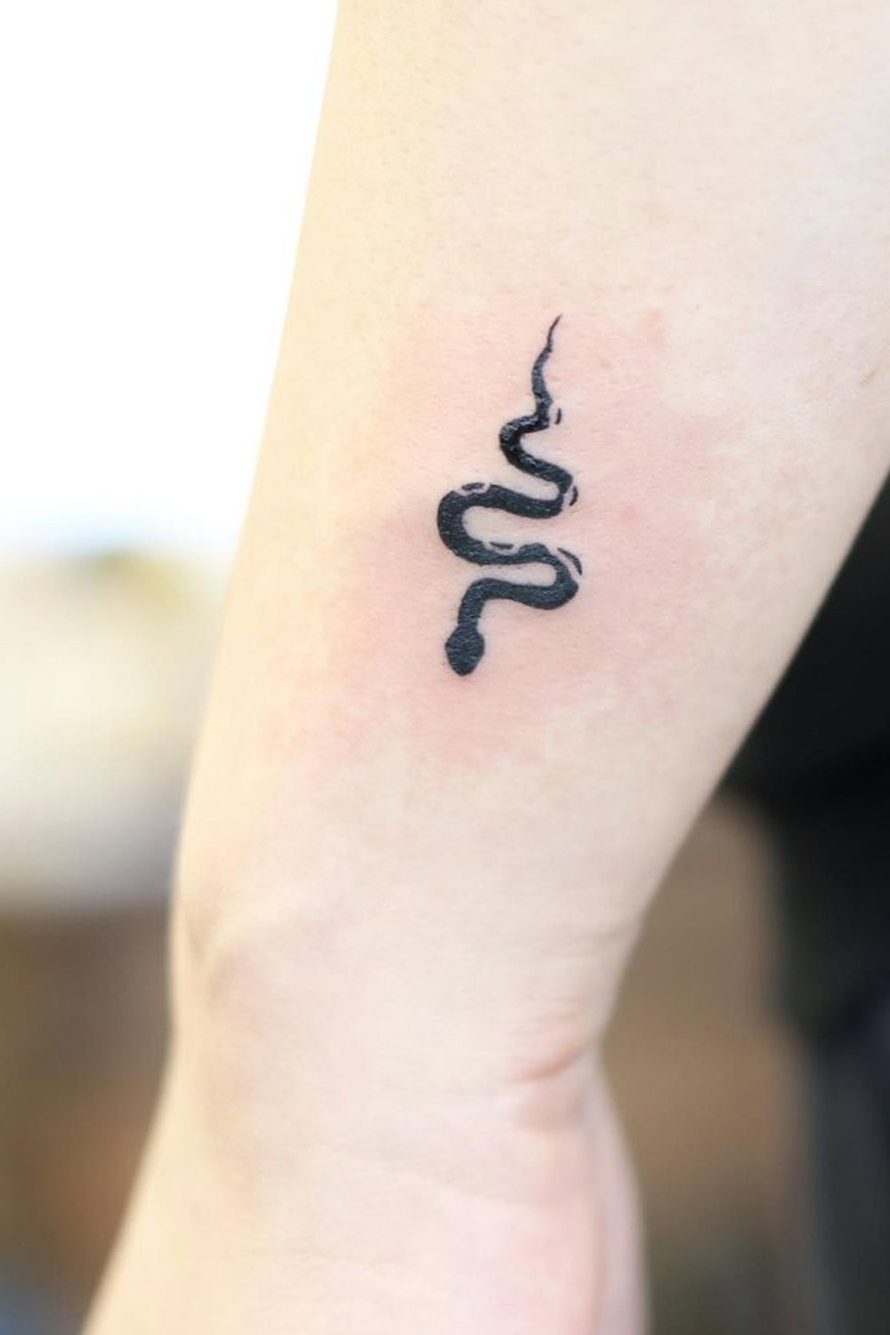 Snake tattoo on the inner arm.