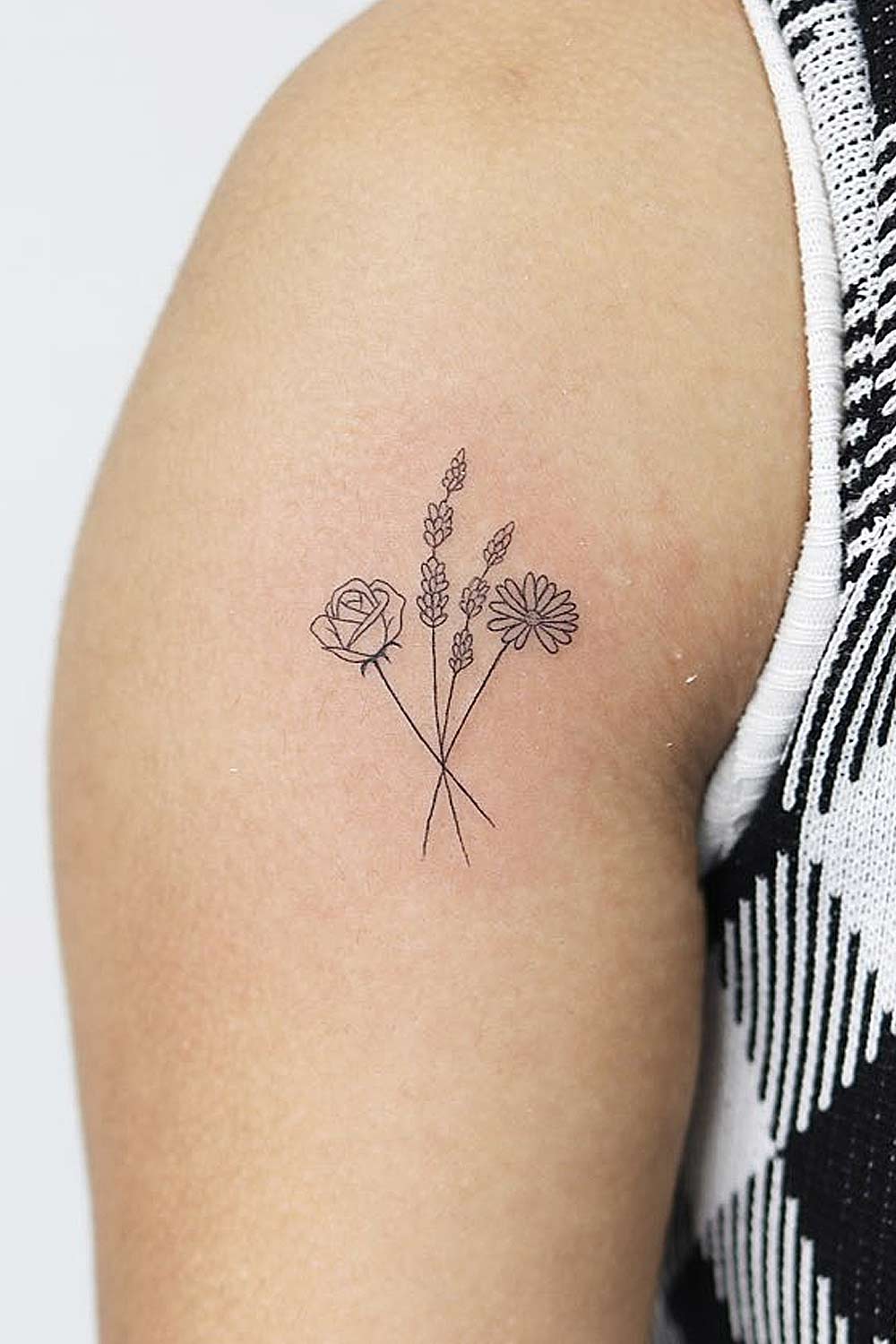 Daisy flowers tattoo located on the upper arm