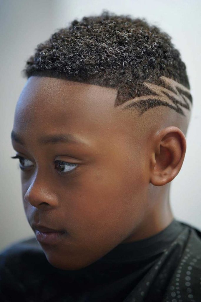 Children hairdresser cutting little boy against a dark background.  Contented cute preschooler boy getting the haircut. The hand of the master  have tattoo with the word shave Stock Photo - Alamy