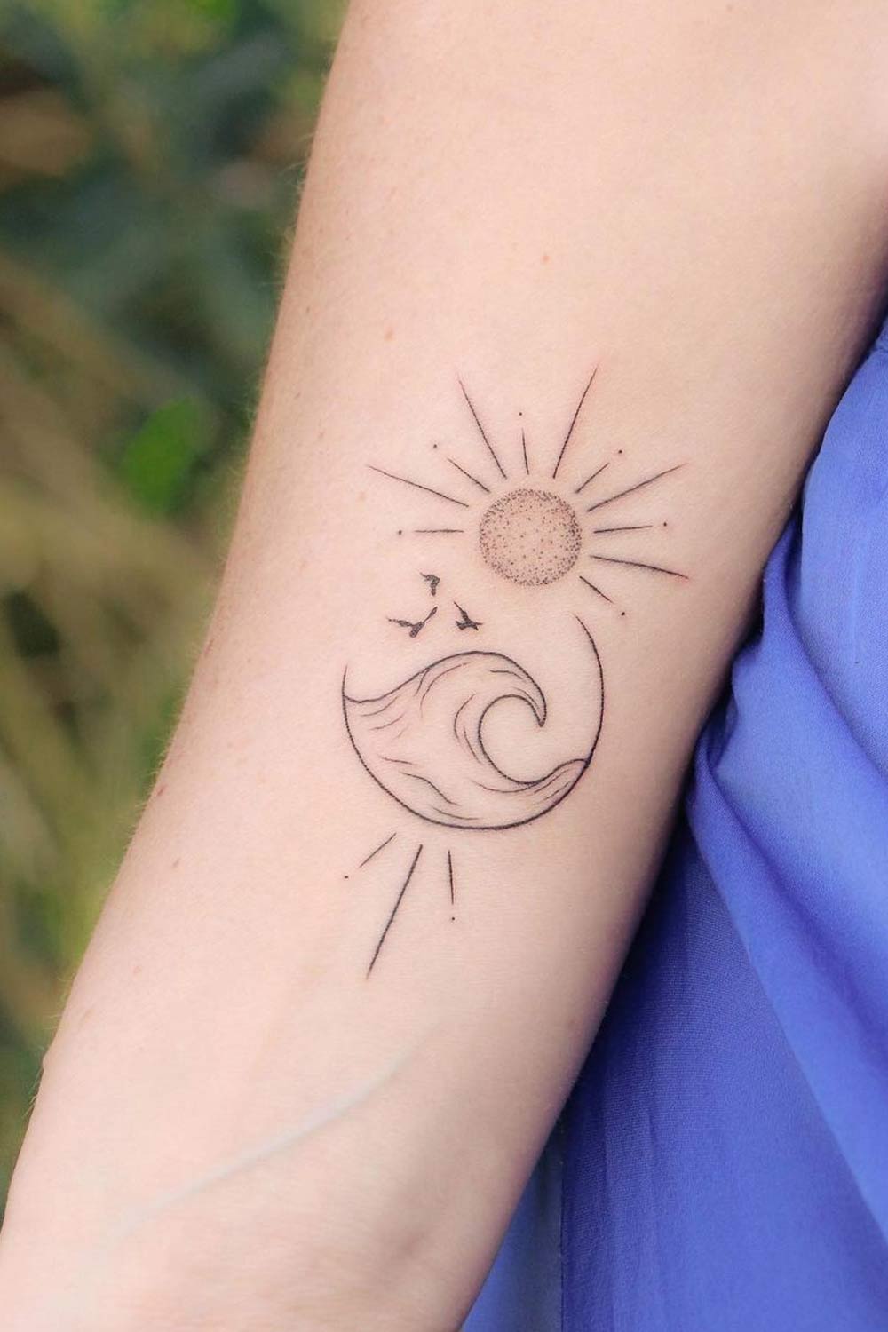 Minimalist sun and wave tattoo on the hip