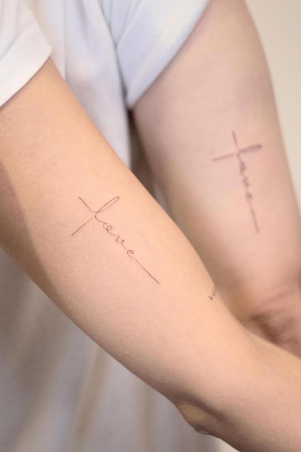 Design de tatuagem de casal com cruz e letras