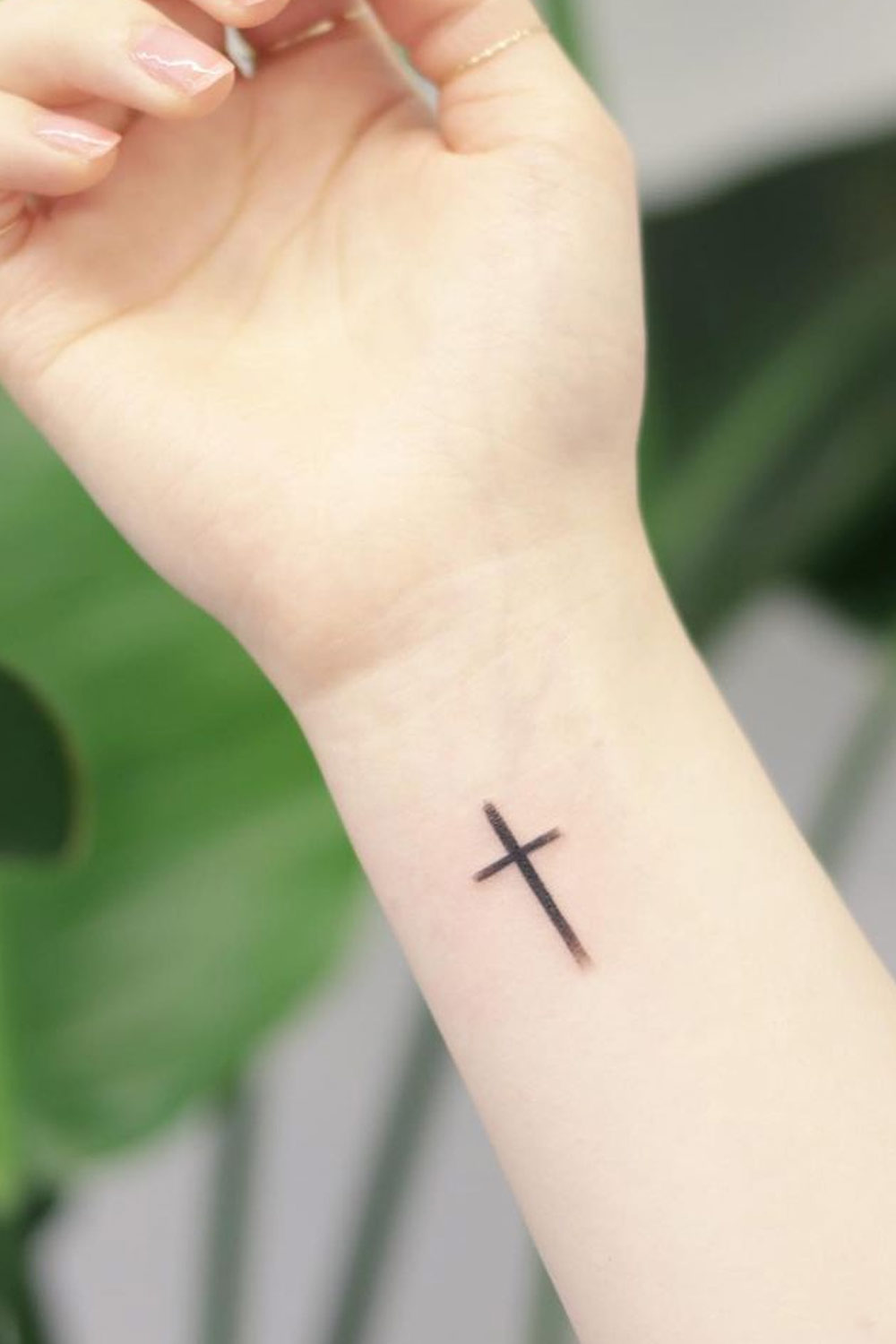 Tatuagem cruzada minimalista no pulso