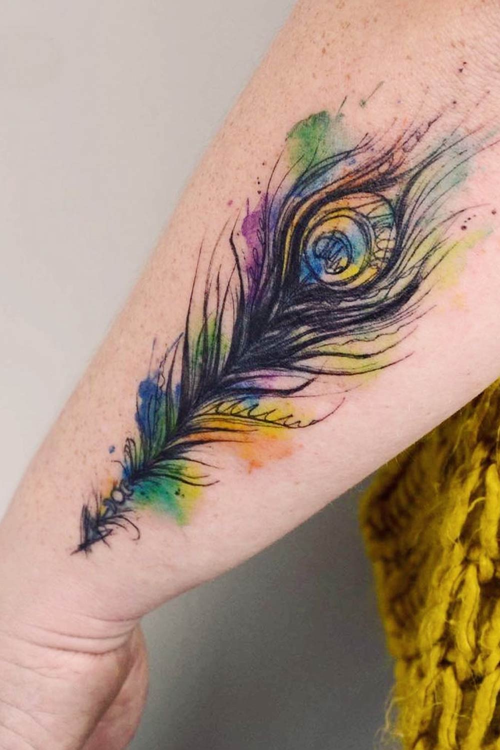 Feather tattoo on the inner forearm.