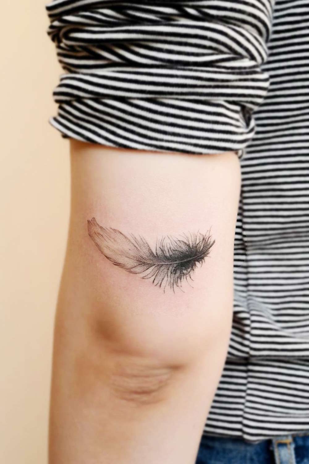 Black Colored Tattoo of a Feather