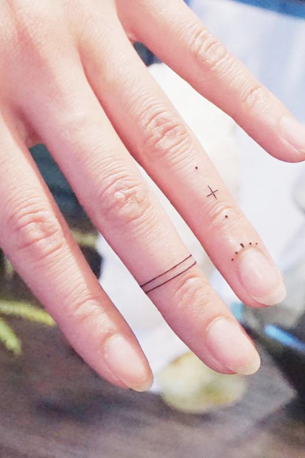 Minimalist cat tattoo on the middle finger.