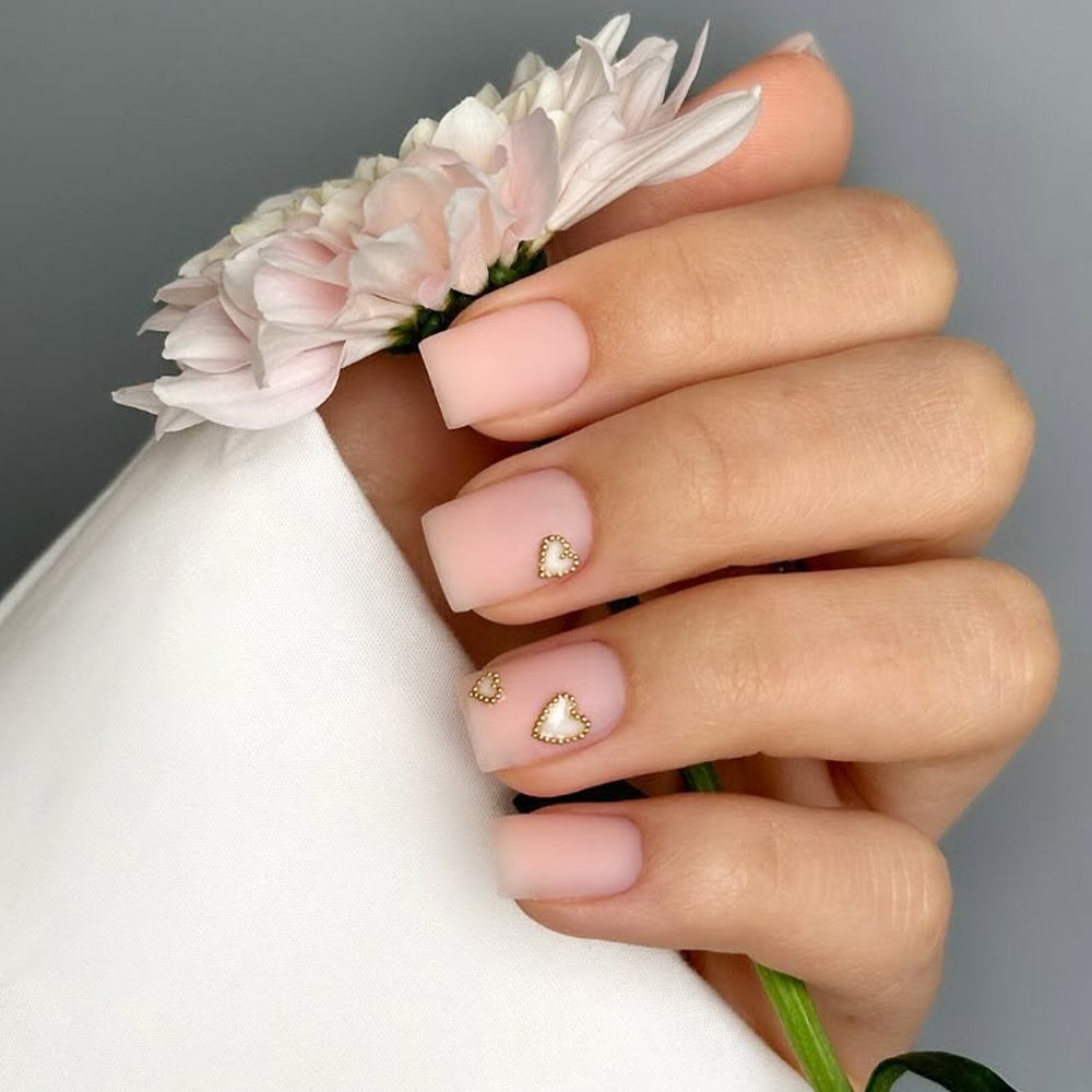 Romantic Nude-Pink Nails with Subtle Heart Accents